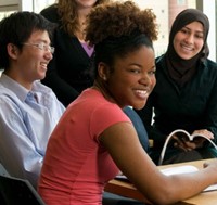 smiling Black female student at table with other students