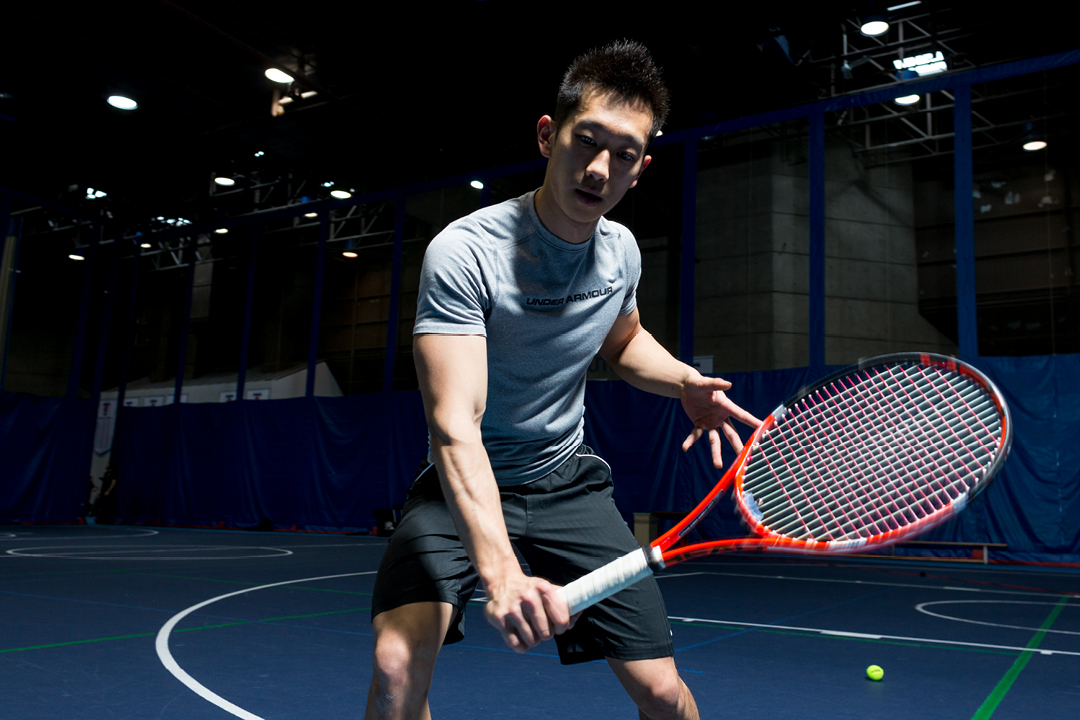 asian young man with tennis racket