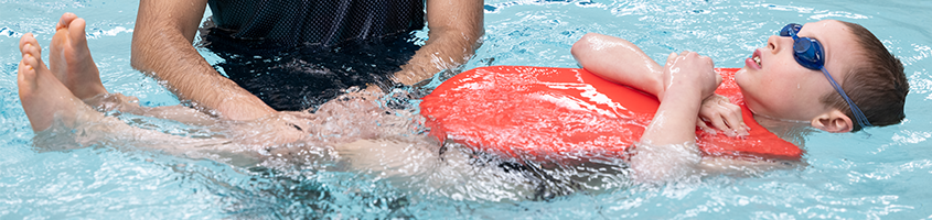 Kid floating in the pool learning first-aid