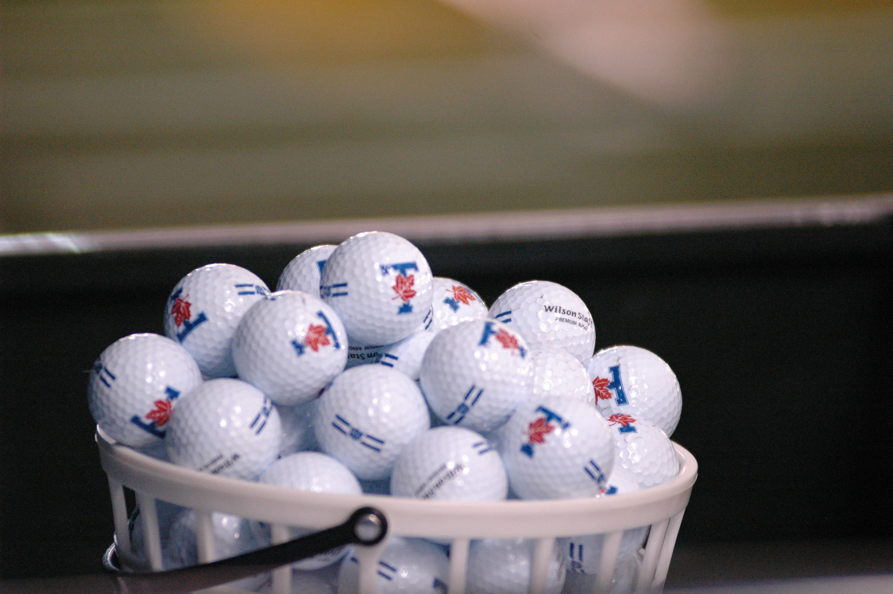 Bucket of golf balls with UofT logo on them