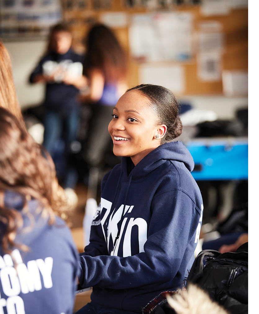 Black female student in hoodie chatting with another student