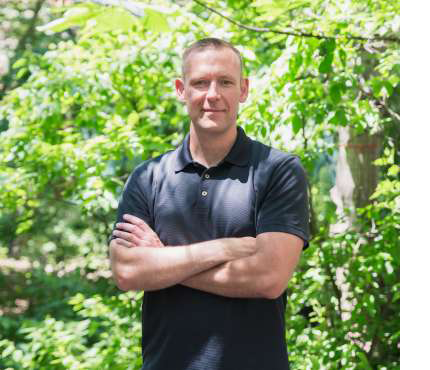 portrait of simon darnell outside with leafy green background