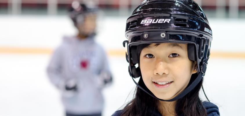 young girl wearing a hockey helmet
