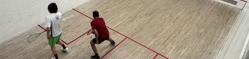 Two men with raquets playing squash