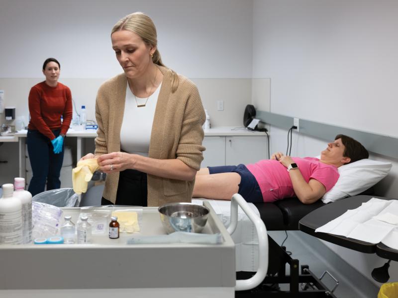 Dr. Jenna Gillen completes a muscle biopsy on a study participant, who lies down in the background