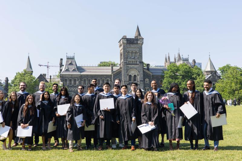 Graduating KPE students pose of University College on Front Campus