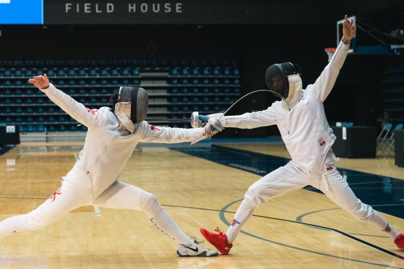 Two athletes in full fencing gear provide a demonstration in the Kimel Family Field House