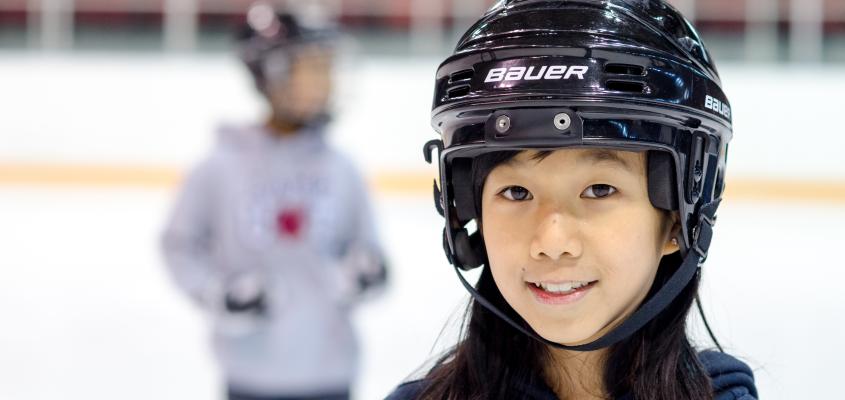 Young Skaters wearing hockey helmets