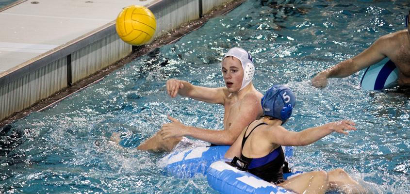 men and women playing innertube Water Polo