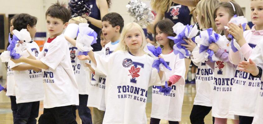 Children cheering at a Varsity Blues game