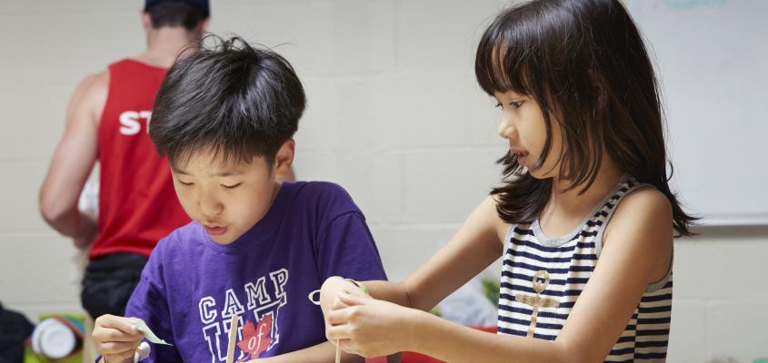 Campers work on a project with various materials