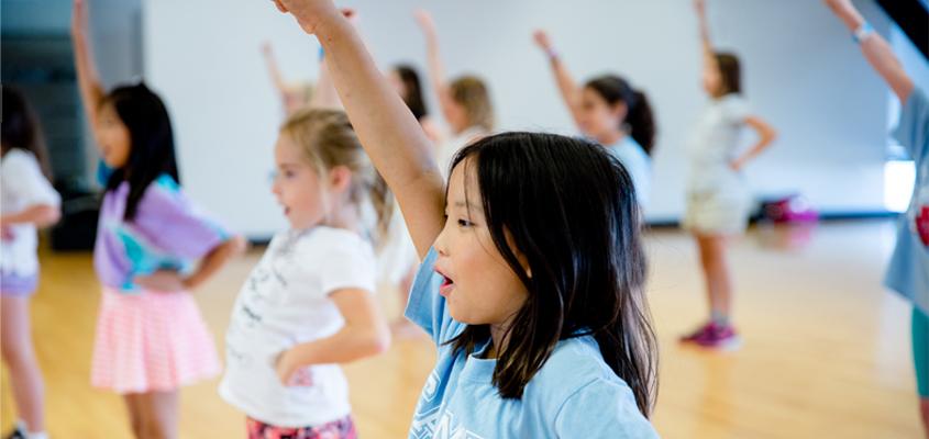 group of female children in cheerleading camp practicing