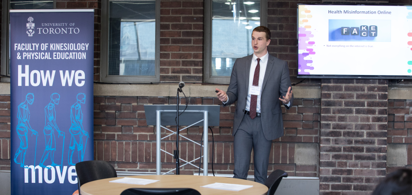 male student in suit presenting at conference