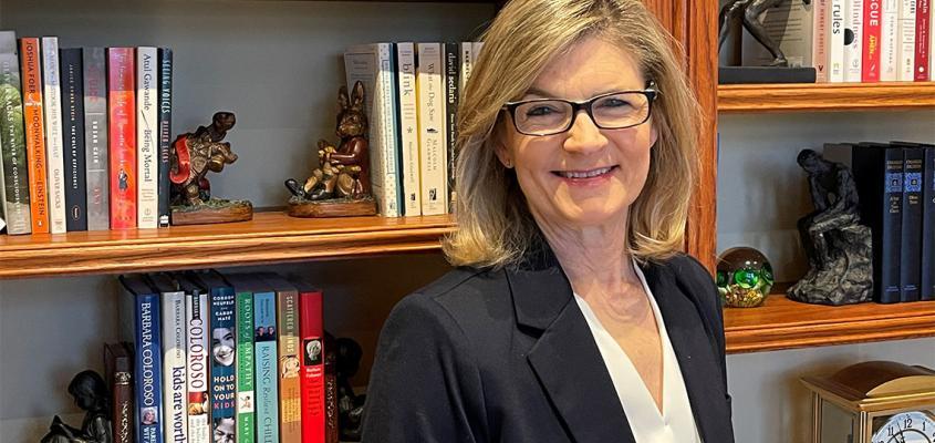 portrait of gretchen kerr in front of bookshelf