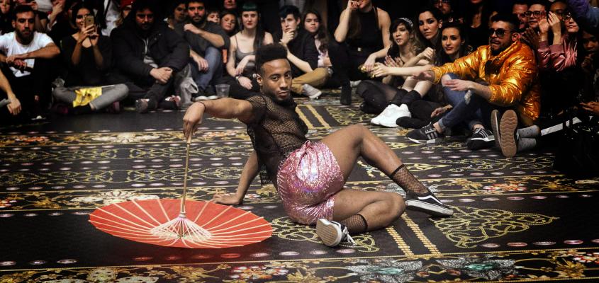 man dancing with umbrella on rug at event