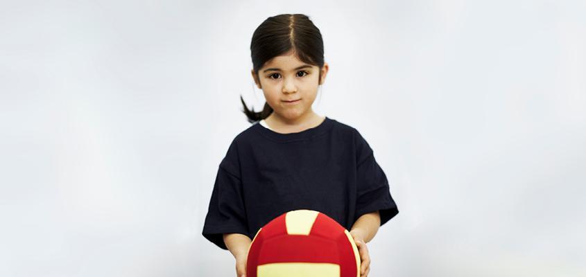 female child holding volleyball