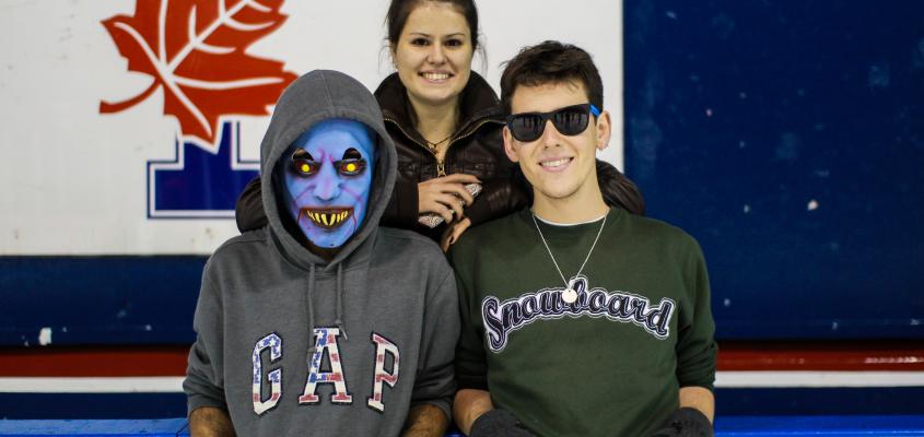 students smiling, one wearing a zombie mask