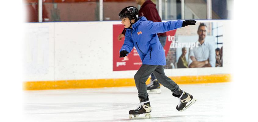 child ice skating in arena