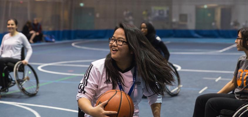 Woman smiling playing wheelchair basketball