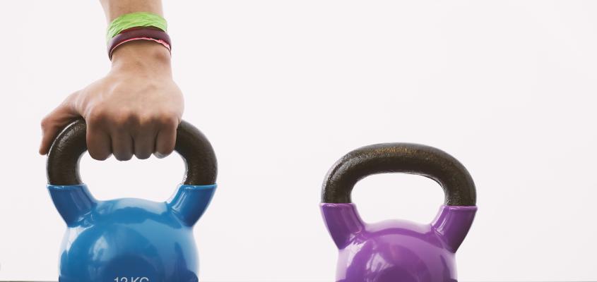 A hand grabbing a blue kettle bell