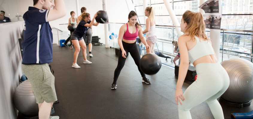 Coach demonstrating exercise to two participants