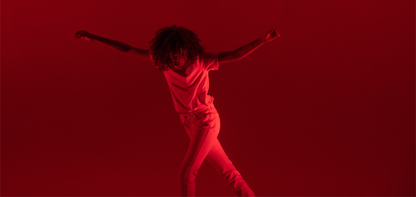 curly-haired woman dancing alone