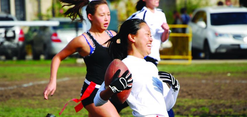 Young women playing a flag football game.