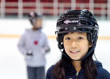 Young Skaters wearing hockey helmets