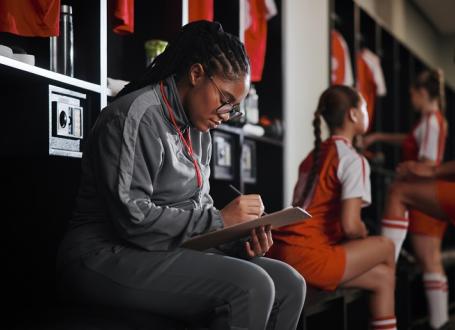 Image of coach taking notes in a change room