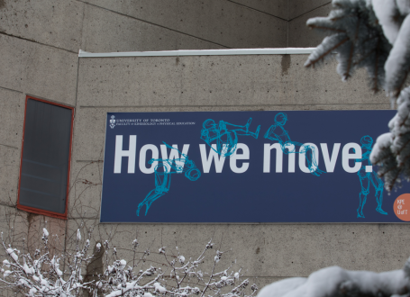 banner on outside of athletic centre with tagline 'how we move' surrounded by trees frosted with snow